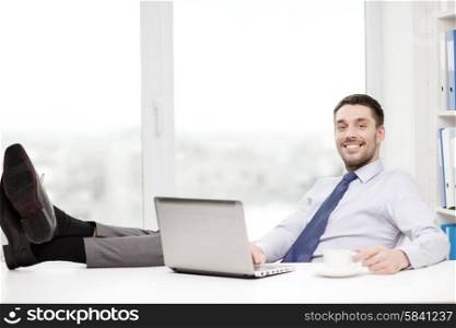 office, business, education, technology and internet concept - smiling businessman or student with laptop computer and coffee at office
