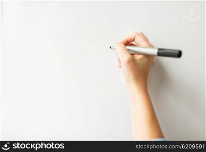 office, business, people and education concept - close up of hand with marker writing or drawing something on white board or wall
