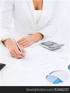 office, business, tax, accounting concept - businesswoman working with calculator in office