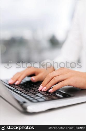 office, business, technology and internet concept - businesswoman using her laptop computer