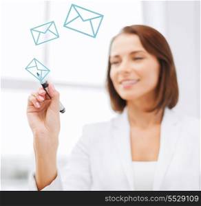 office, business, technology concept - businesswoman drawing envelopes in the air with marker