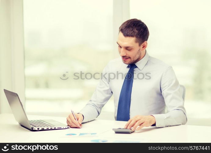 office, business, technology, finances and internet concept - smiling businessman with laptop computer and documents at office