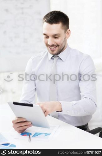 office, business, technology, finances and internet concept - smiling businessman with tablet pc computer and documents in office
