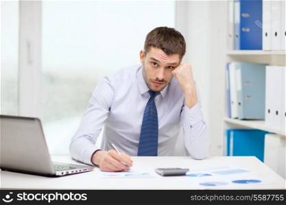 office, business, technology, finances and internet concept - stressed businessman with laptop computer and documents at office