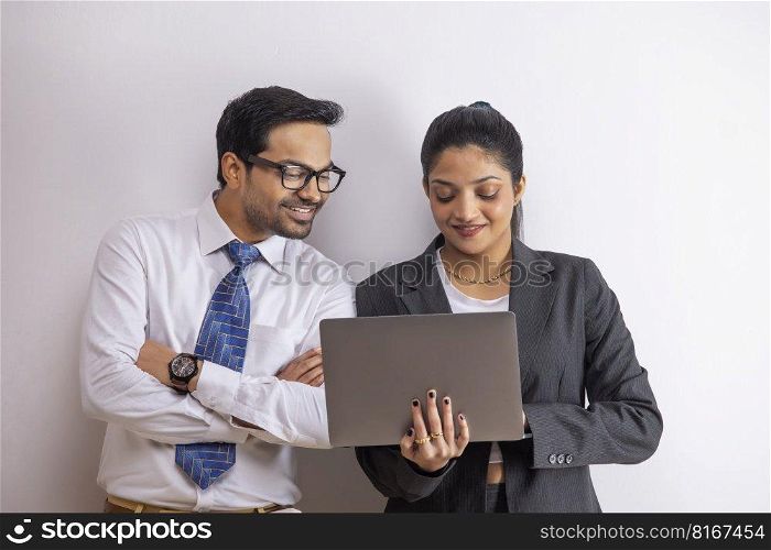Office colleagues together doing office work using laptop