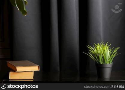 Office creative desk with books and houseplant on black table. High quality photo.. Office creative desk with books and houseplant on black table. High quality photo