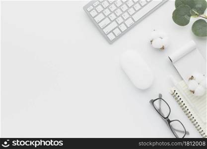 Office desk table top view with office supply and cotton flower, white table with copy space, White color workplace composition, flat lay