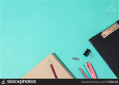 Office desk table with book and pencil. Top view copy space.Green background.