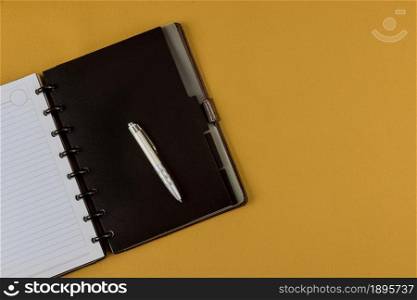Office desk top view with pencil and blank notebook on yellow background. Office desk top view with pencil and notebook on yellow background