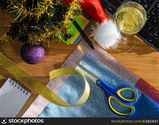 office desk with christmas accessories, wrapping paper for presents and stationery, view from above