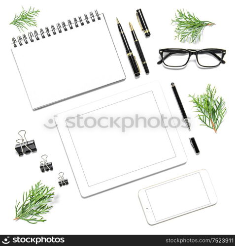 Office desk with digital gadgets and Christmas decoration on white background. Minimalistic flat lay