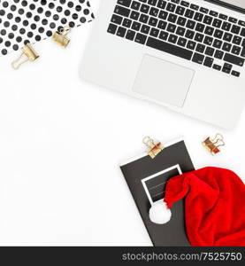 Office desk with laptop and red Christmas decoration. Business flat lay