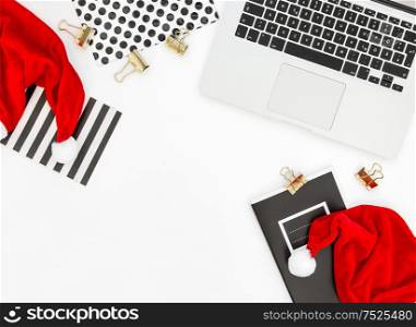 Office desk with laptop and red Christmas decoration. Business Holidays