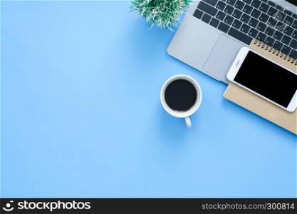 Office desk working space - Flat lay top view mockup photo of working space with laptop, smartphone, coffee up and notebook on blue pastel background. Pastel blue color background working desk concept