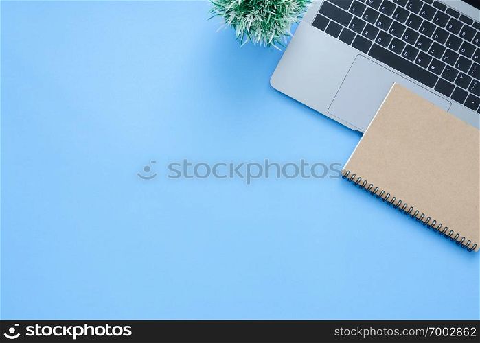 Office desk working space - Flat lay top view mockup photo of working space with laptop and notebook placing on blue pastel background. Pastel blue color copy space working desk concept.