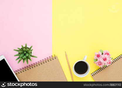 Office desk working space - Flat lay top view photo of working space with blank mock up tablet, coffee cup and notebook on pastel background. Pastel pink yellow color copy space working desk concept.