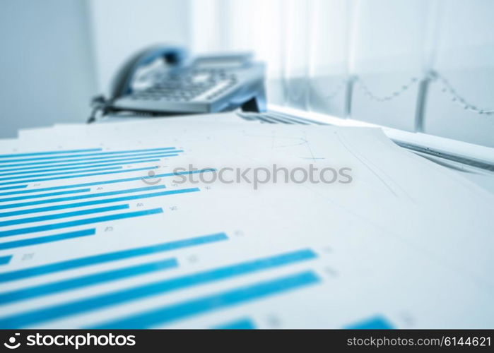 Office documents on a desk with a telephone