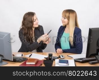 Office employee offers to a colleague sitting next to lipstick