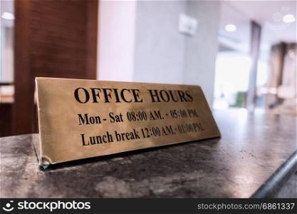 Office Hours gold metal sign on desk for business opening with announcement and give information for customer