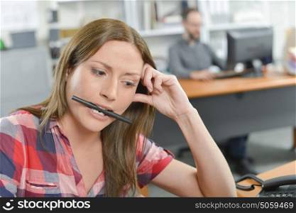 Office lady holding pen between her teeth