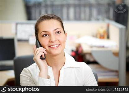 Office life. Beautiful woman talking over phone.