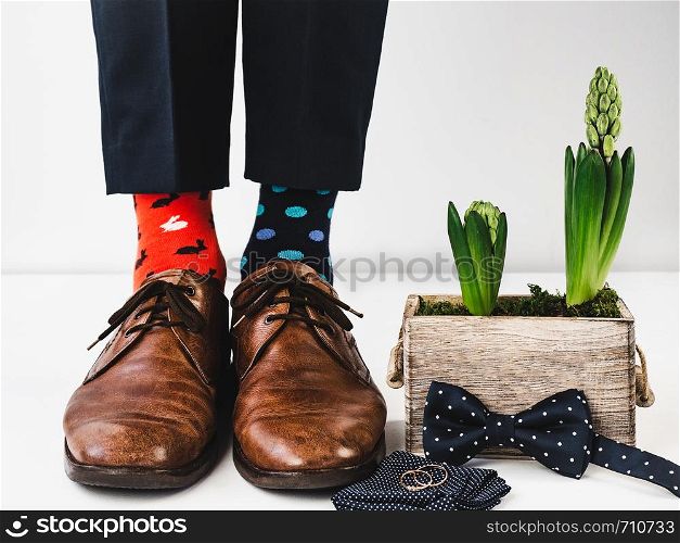 Office manager standing in stylish shoes, black pants and bright, colorful socks on a white, isolated background. Close-up. Studio photo. Concept of lifestyle, fun and elegance. Office manager standing in stylish shoes. Closeup