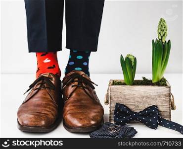 Office manager standing in stylish shoes, black pants and bright, colorful socks on a white, isolated background. Close-up. Studio photo. Concept of lifestyle, fun and elegance. Office manager standing in stylish shoes. Closeup