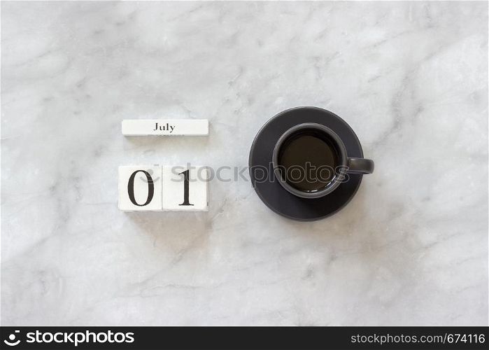 Office or home table desk. Wooden cubes calendar July 1st and cup of coffee on marble background Concept stylish workplace Flat lay Top view Minimal style.. Office or home table desk. Wooden cubes calendar July 1st and cup of coffee on marble background Concept stylish workplace Flat lay Top view Minimal style