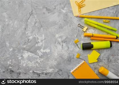 Office stationery supplies in yellow tones closeup, marble background. School or education accessories, writing and drawing tools, pencils and rubbers, etc.. Office stationery supplies in yellow tones closeup