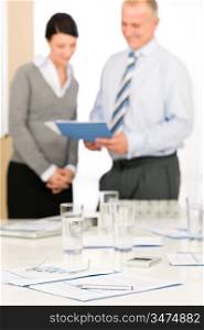 Office supply on table - two business people out of focus