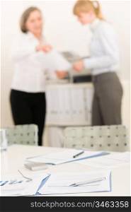 Office supply on table - two business women out of focus