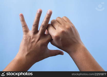 Office syndrome concept. Index finger is massaged and stretched after working. Close up shot isolate on blue background. Backhand view.