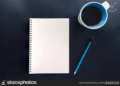 Office table with blank notepad, pencil, and cup of coffee.