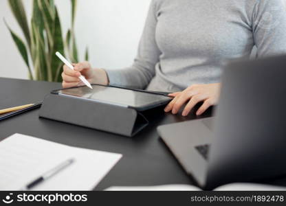 Office work concept a female officer using her tablet to work on a document job in the office.