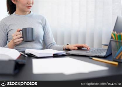 Office work concept a female secretary holding a cup of coffee relaxingly doing her job.