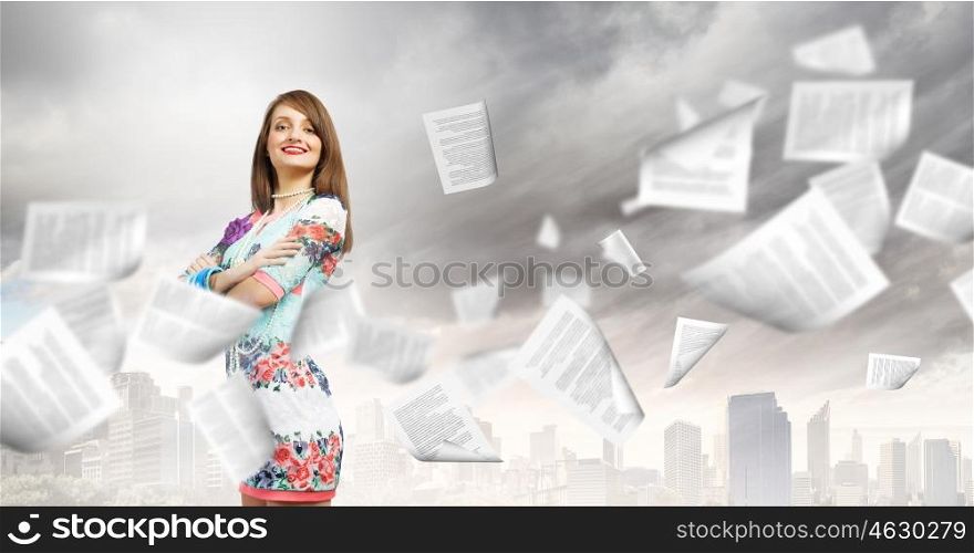 Office work. Young woman in casual and paper flying in air