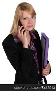 Office worker carrying a file folder while talking on the phone