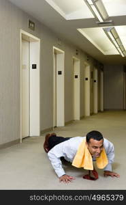 Office worker doing push ups in corridor