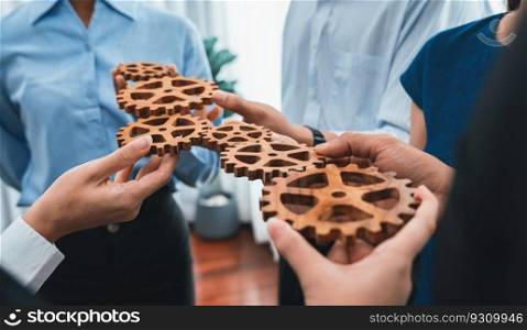 Office worker holding cog wheel as unity and teamwork in corporate workplace concept. Diverse colleague business people showing symbol of visionary system and mechanism for business success. Concord. Office worker holding cog wheel as unity and teamwork in workplace. Concord