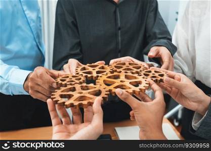 Office worker holding cog wheel as unity and teamwork in corporate workplace concept. Diverse colleague business people showing symbol of visionary system and mechanism for business success. Concord. Office worker holding cog wheel as unity and teamwork in workplace. Concord