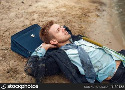 Office worker in torn suit resting on the beach on desert island. Business risk, collapse or bankruptcy concept. Office worker resting on the beach, desert island