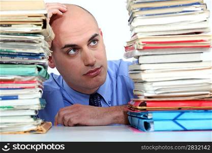 Office worker looking at stacks of files