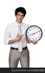 Office worker pointing his finger to a clock