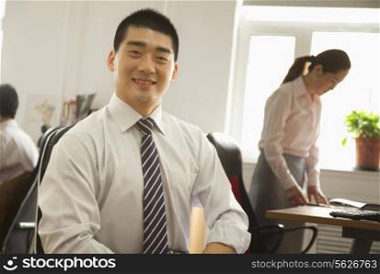 Office worker seating and smiling, portrait