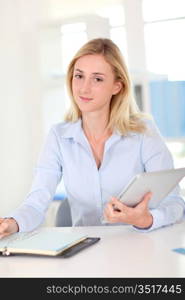 Office worker sitting at table with agenda and touchpad