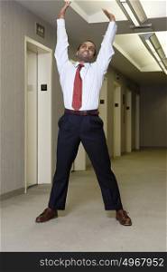 Office worker stretching in corridor