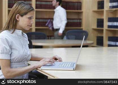 Office worker using laptop in legal office, side view