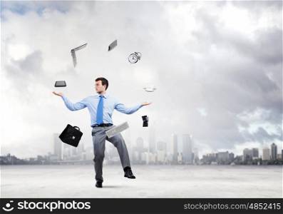 Office worker. Young businessman juggling with business items against urban scene