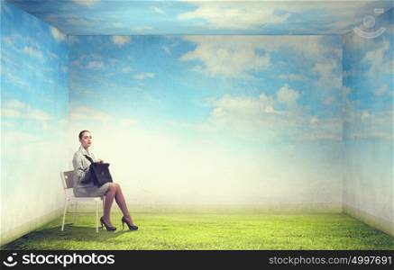 Office worker. Young businesswoman sitting in chair against nature landscape