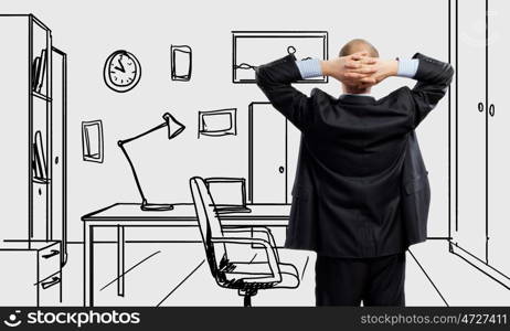 Office worker. Young confident businessman standing in drawn office